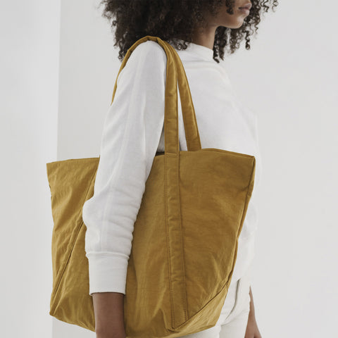 Collection image of a woman holding a large yellow Baggu bag