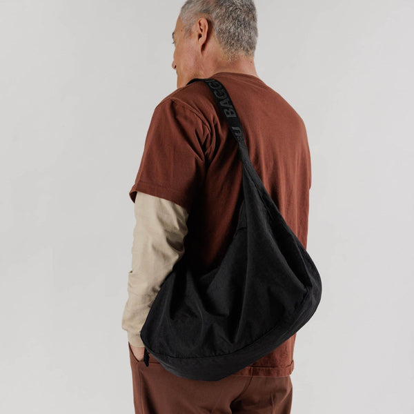 baggu large nylon crescent bag in black on man