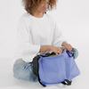 Baggu Nylon Messenger Bag in Pansy blue being packed by girl